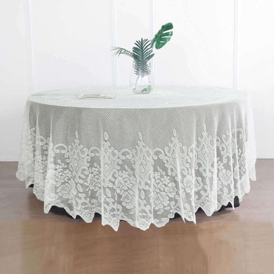 Lace tablecloth draped over a round table with a vase and plant.