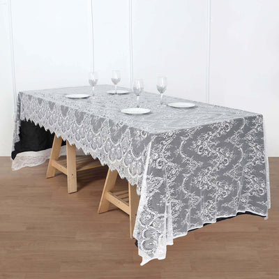 Elegant lace tablecloth on a wooden table with plates and glasses.