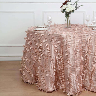 Pink leaf-pattern tablecloth draped over a round table in a staged setting.