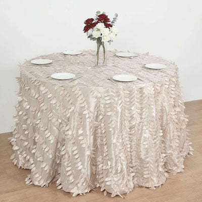 Elegant round table covered with a leaf-patterned beige tablecloth and floral centerpiece.