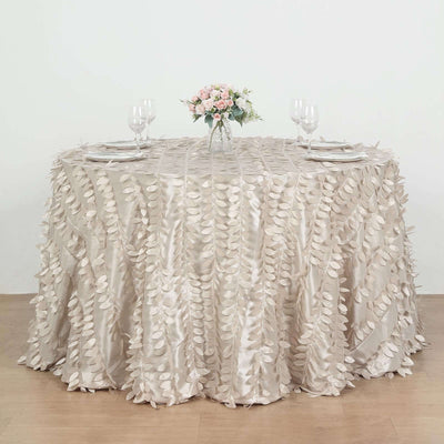 Elegant leaf-patterned tablecloth draped on a round table with floral centerpiece.