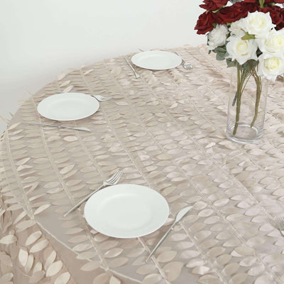Elegant table setting with leaf-patterned tablecloth, plates, and floral centerpiece.