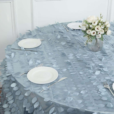 Round blue leaf-pattern tablecloth with white plates and floral centerpiece.