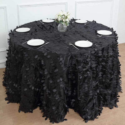 Black tablecloth with leaf design on a round table set for dining.