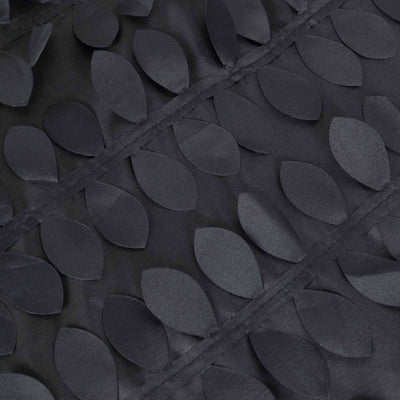 Black fabric with textured leaf patterns, ideal for stylish decor or fashion.