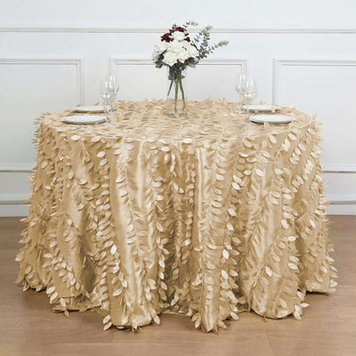 Gold tablecloth with leaf design draped over a round table set for dining.