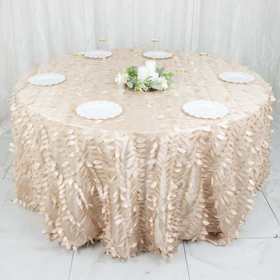 Elegant round table covered with a beige leaf-patterned tablecloth and white plates.