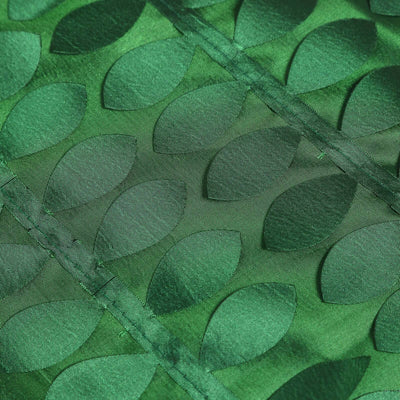 Green fabric with leaf patterns, showcasing rich texture and detail.
