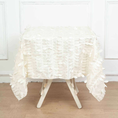 White textured tablecloth with leaf appliqués on a wooden table.