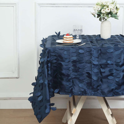 Navy blue tablecloth with leaf design on a dining table setting.