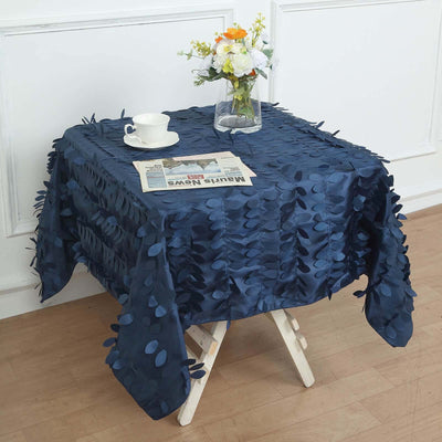 Navy blue tablecloth with leaf appliqués on a wooden table setting.