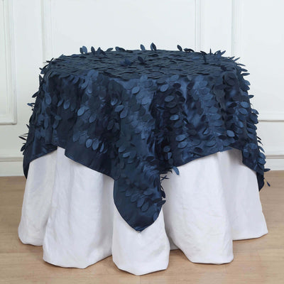 Navy tablecloth with leaf appliqués on a white table setup.