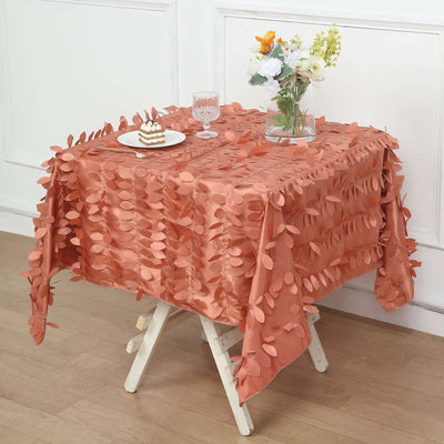 Textured coral tablecloth draped over a table with decor and dessert.