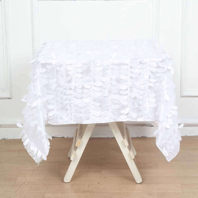 White tablecloth with textured leaf design draped over a table.
