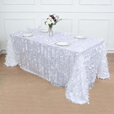 White tablecloth with leaf design, elegantly draped over a table with floral centerpiece.