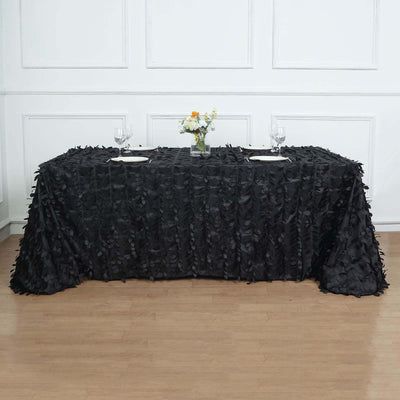 Black ruffled tablecloth draped over a table with floral centerpiece and glassware.