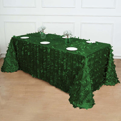 Green leaf-patterned tablecloth draped over a table with decorative plates.