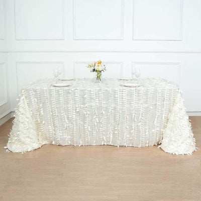 White floral tablecloth draped over a table set for dining.