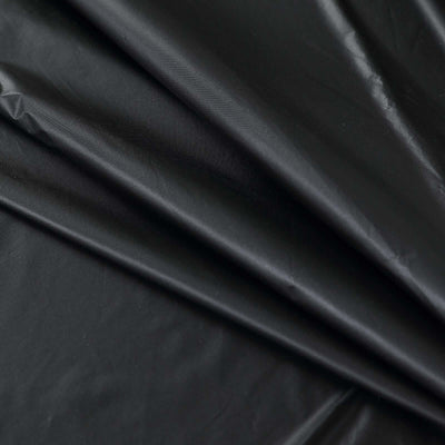 Black fabric with a smooth texture and folded layers.