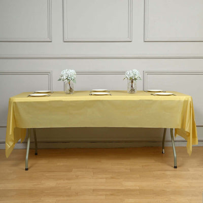 Yellow tablecloth draped over table with floral centerpieces.