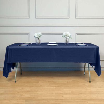 Navy tablecloth on a wooden table with floral centerpieces and place settings.