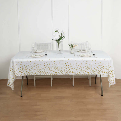 Gold star tablecloth on a dining table set with glassware and floral centerpiece.