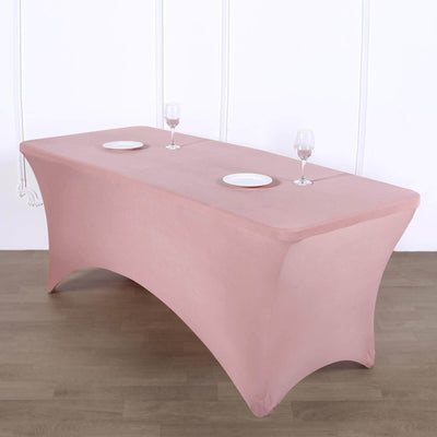 Pink table cover on a rectangular table with plates and glasses.