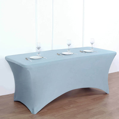 Blue fitted table cover draped over a rectangular table with plates and glasses.
