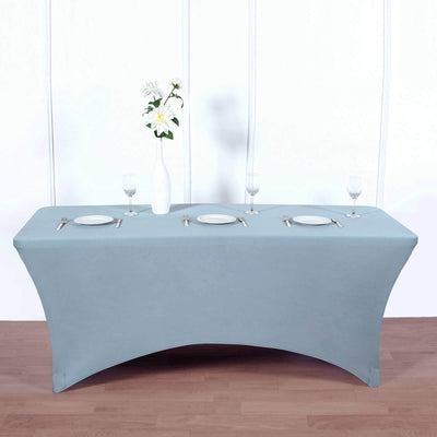 Blue table cover draped over a table set for dinner with plates and glasses.