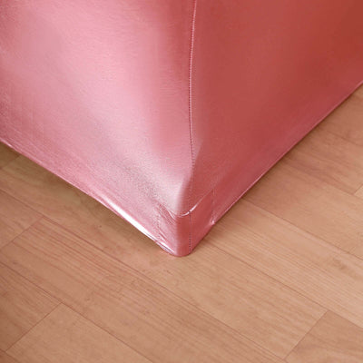 Pink metallic corner of a sofa on wooden flooring.