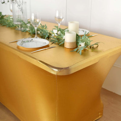 Gold table cover with elegant decor and table settings for events.