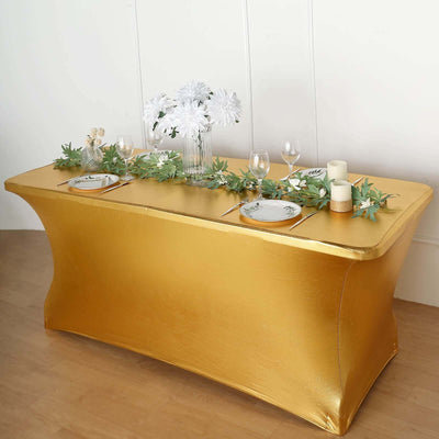 Gold table cover with floral centerpiece and elegant dinnerware.