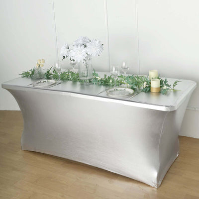 Silver table cover with flowers and candles for elegant event decor.