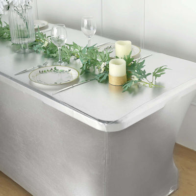 Silver table cover with elegant table setting, candles, and greenery.