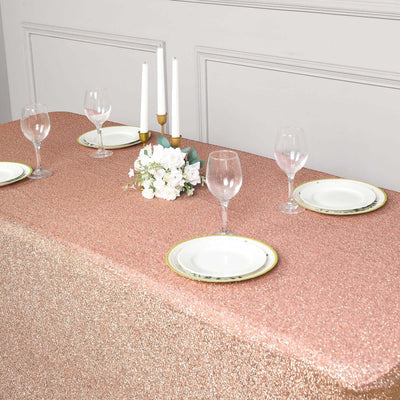 Elegant rose gold sequin tablecloth with plates and glasses for a stylish dining setup.