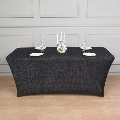 Black table cover draped over a banquet table with elegant dinnerware and candles.