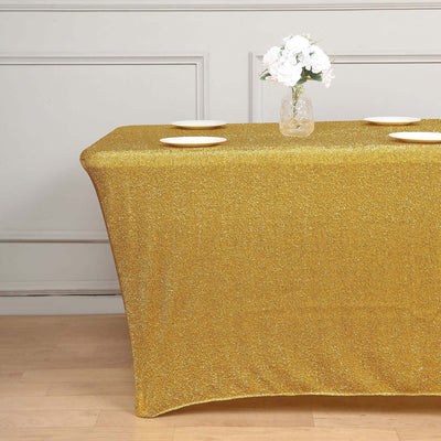 Gold glitter table cover with plates and a flower vase in a staged setting.