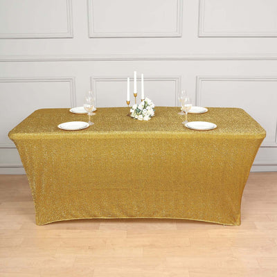 Gold glitter tablecloth set on a dining table with plates and candles.