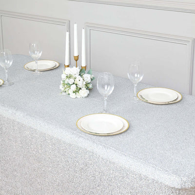 Elegant silver table setting with plates and floral centerpiece.