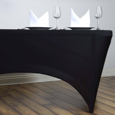 Black table cover with plates, glasses, and folded napkins.