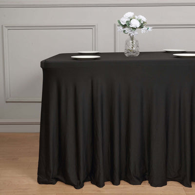 Black tablecloth draped over a table with a vase of flowers