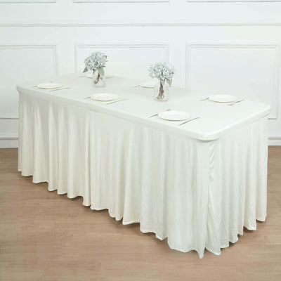 White tablecloth draped over a long table with floral centerpieces.