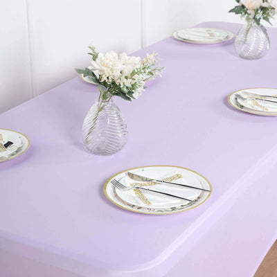 Elegant lavender table setting with floral arrangements and decorative plates.