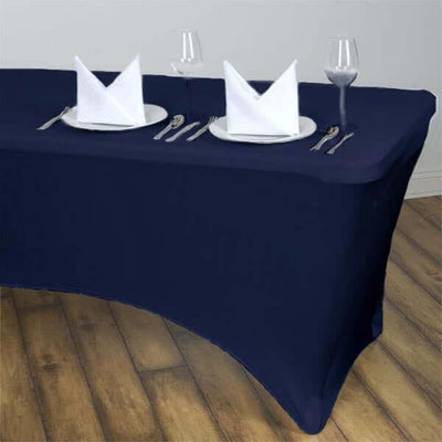 Navy tablecloth with set dining table, white plates, napkins, and glasses.