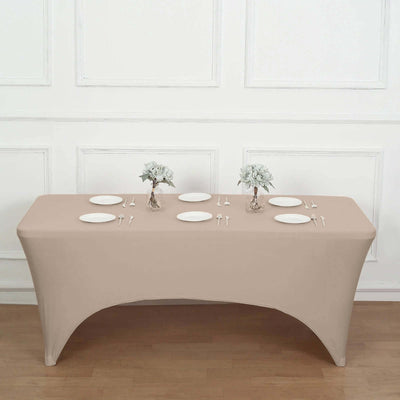 Beige table cover with plates and floral centerpieces in a staged dining setup.