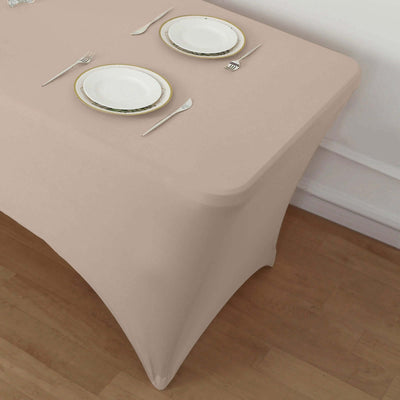 Beige table cover with elegant dinnerware set on a wooden table.