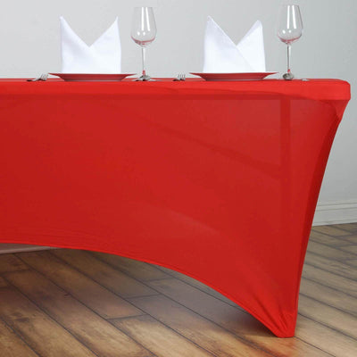 Red table cover with white napkins and plates set for dining.