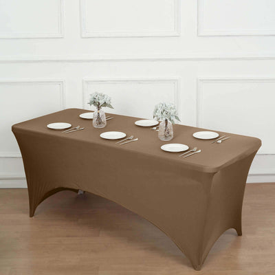 Brown fitted table cover on a dining table set with plates and floral centerpieces.