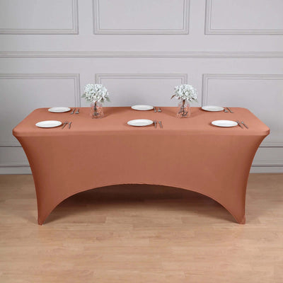 Brown stretch table cover with white plates and floral arrangements.