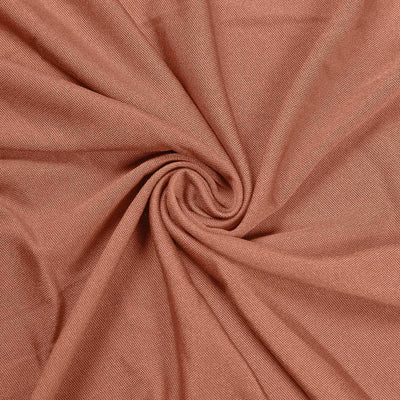 Textured rust-colored fabric in a swirling pattern.